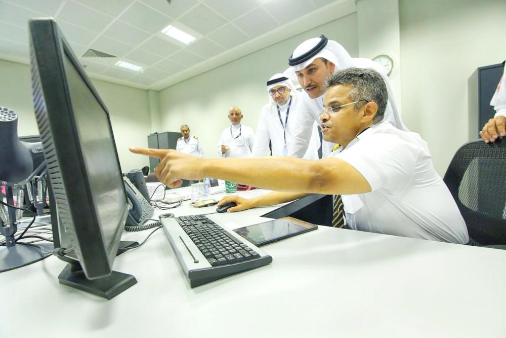 



صالح الجاسر مستمعاً لشرح من أحد العاملين بمطار الملك عبدالعزيز. 