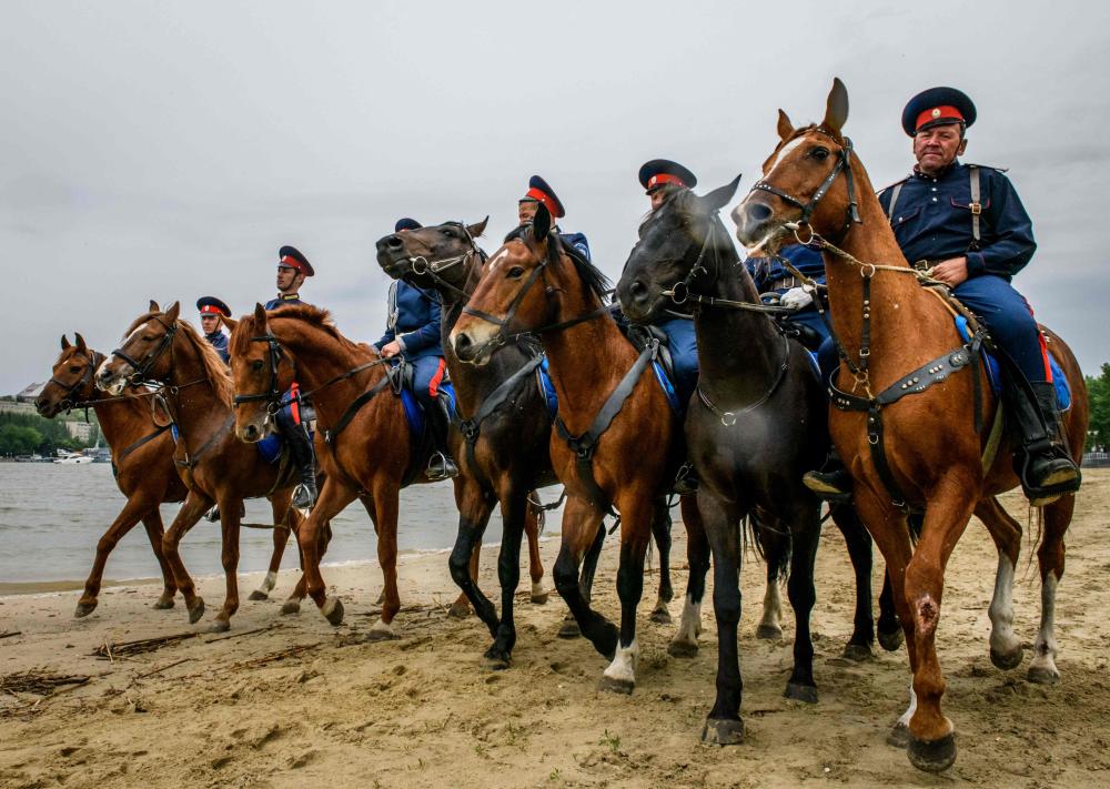 Don Cossacks practise their riding skills on the left bank of Don river outside Rostov Arena in the southern Russian city of Rostov-on-Don on May 13, 2018. The Rostov Arena will host five football matches of the 2018 FIFA World Cup. / AFP / Mladen ANTONOV
