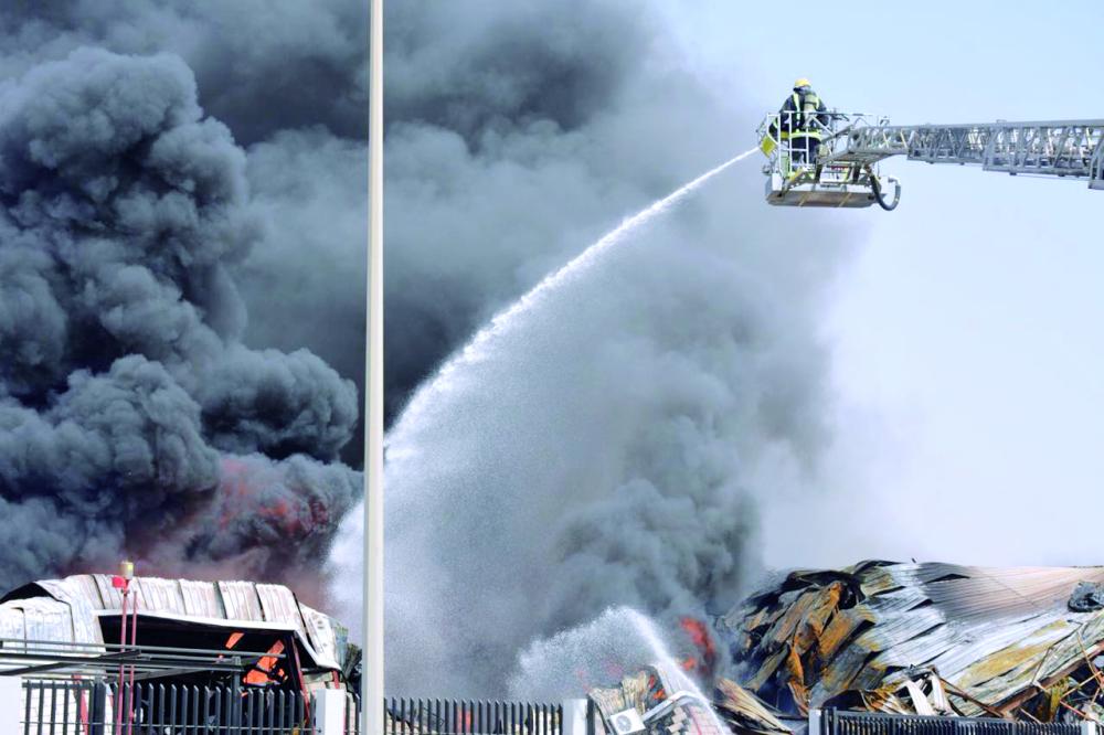 



دخان كثيف متصاعد من الموقع، ورجل إطفاء يوجه خرطوم المياه تجاه النيران. (عكاظ)