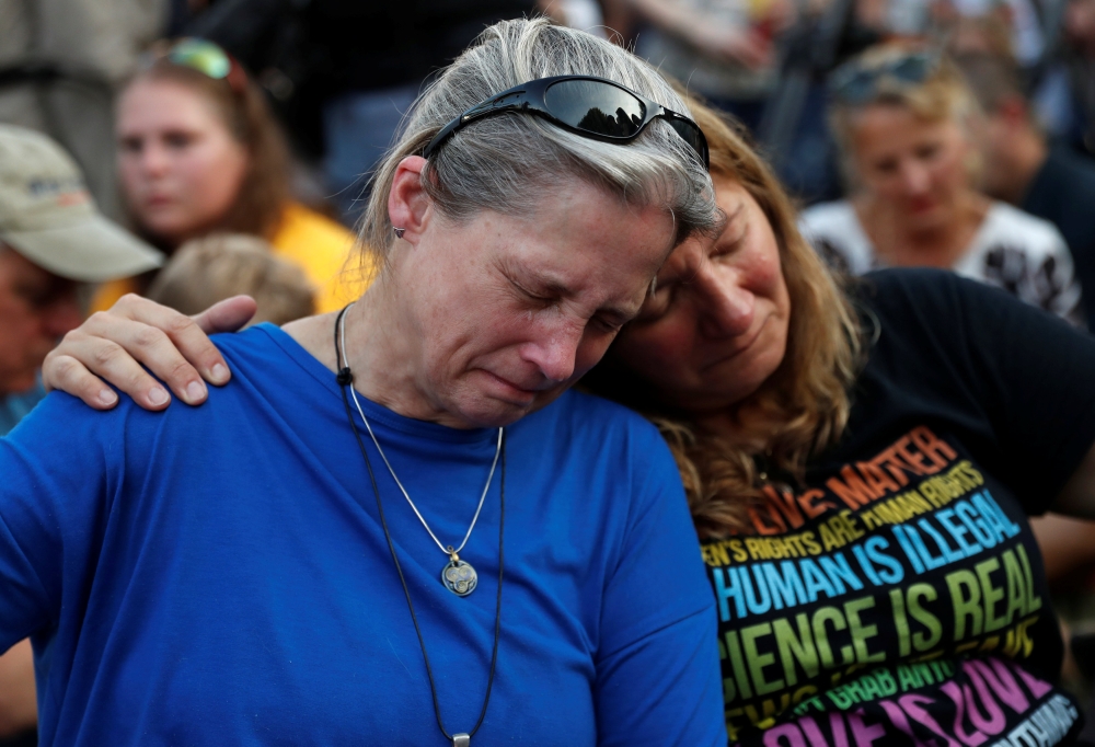 Community members Carol Geithner, left, and Yasemine Jamison take part in a candlelight vigil near the Capital Gazette, the day after a gunman killed five people inside the newspaper's building in Annapolis, Maryland, U.S., June 29, 2018. REUTERS/Leah Millis