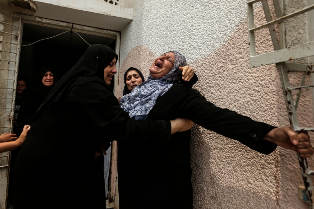 Palestinians and relatives mourn over the death of 15-year-old protester Othman Rami Halles during his funeral east of Gaza City on July 14, 2018. A Palestinian teenager was shot dead Friday by Israeli soldiers during clashes near the Gaza Strip's border with Israel, the territory's health ministry said. Fifteen-year-old Othman Rami Halles was killed east of Gaza City, while 25 other Palestinians were wounded as protests along the frontier spilt over into clashes, ministry spokesman Ashraf Al-Qodra said. 
 / AFP / MAHMUD HAMS
