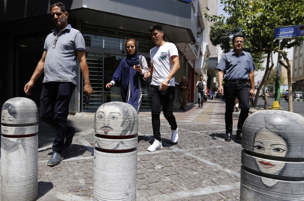 Iranians walk at a street in the capital Tehran on August 8, 2018. US President Donald Trump warned the world the previous day against doing business with Iran as Washington reimposed 