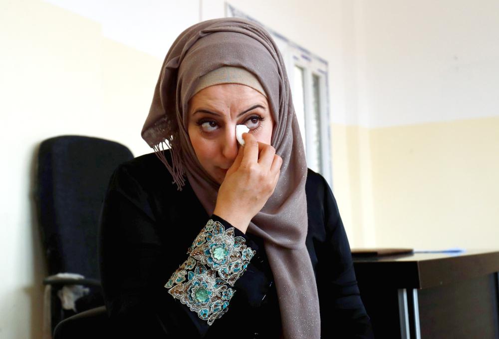 أم سورية لثلاثة أطفال، تبكي وهي تتحدث عن زوجها عبد الإله الذي اعتقله تنظيم داعش قبل ثلاث سنوات متهما بالتآمر مع قوات سورية الديمقراطية المدعومة من الولايات المتحدة. (أ.ف.ب)