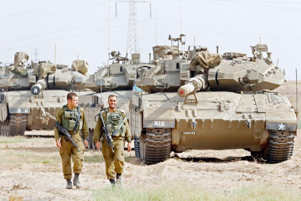 



 حشود من الدبابات والجنود الإسرائيليين على الحدود مع غزة أمس، وسط مخاوف من نشوب حرب جديدة.  (أ ف ب)
