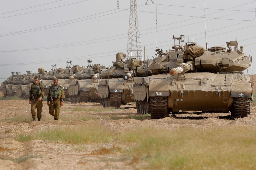 Israeli Merkava tanks are stationed in an open area near Israel's border with the Gaza Strip on October 19, 2018, after Gaza's Islamist rulers Hamas pledged to launch an investigation into rocket fire at Israel earlier this week, in an apparent bid to calm fears of a new war. / AFP / JACK GUEZ
