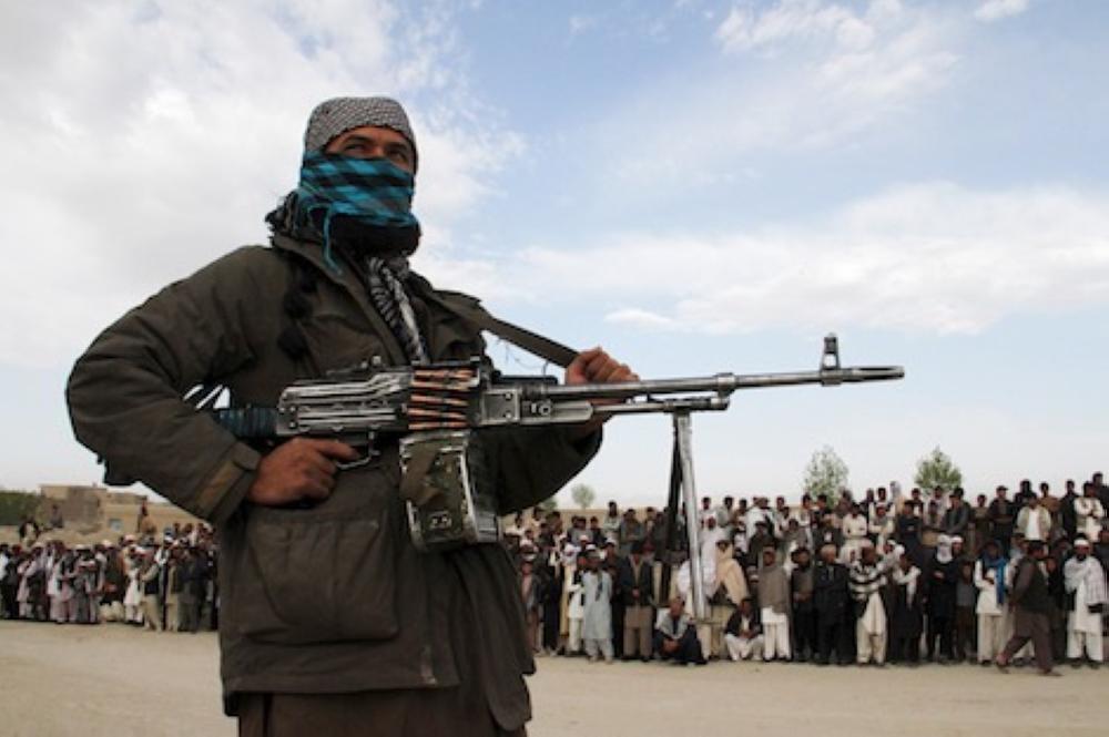 A member of the Taliban insurgent and other people stand at the site during the execution of three men in Ghazni Province April 18, 2015. The Taliban announced the execution of three men accused of murdering a couple during a robbery, saying they had been tried by an Islamic court. The killing was carried out in front of a crowd by Taliban fighters who fired at the men with AK-47s, according to a Reuters witness. Footage seen by Reuters show the men were made to sit on the ground with their eyes blindfolded and their hands tied at the time of their execution. REUTERS/Stringer
