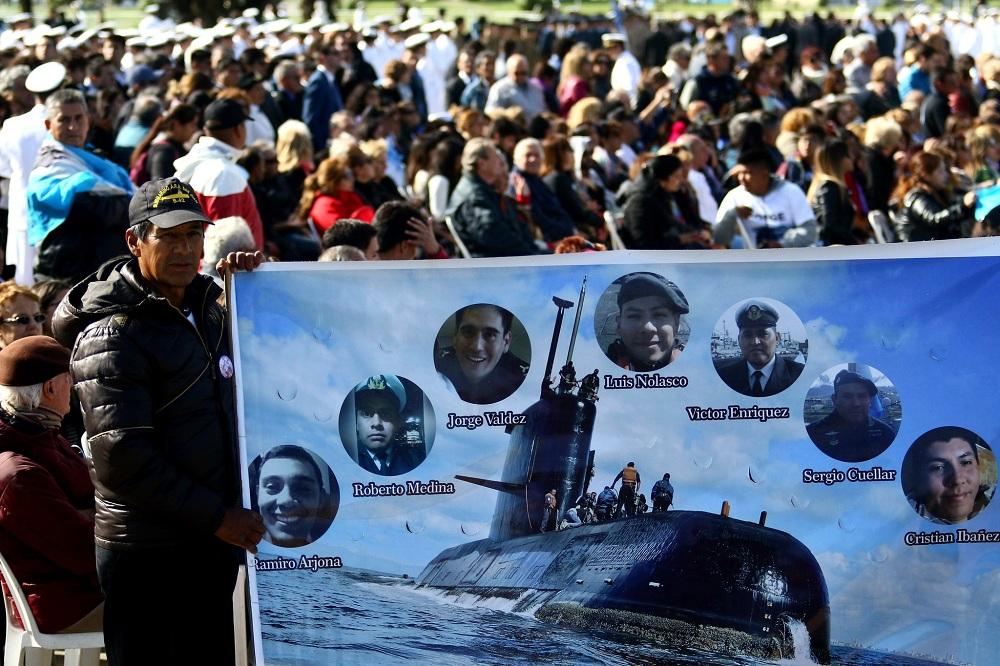 أرجنتيني يحمل لافتة تضم صورة الغواصة وأفرادها