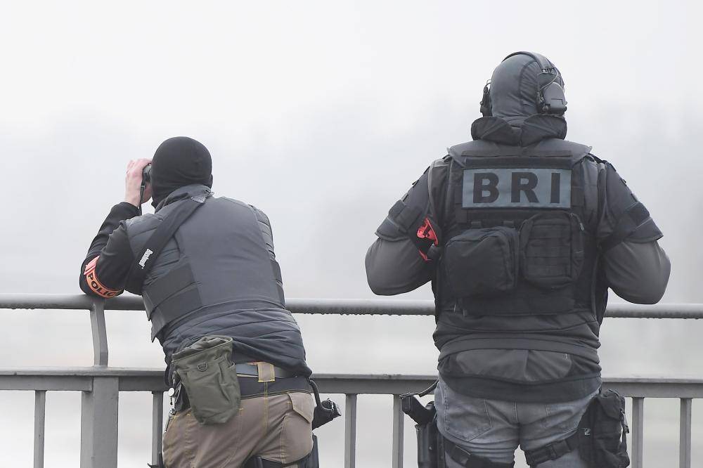 



شرطيان فرنسيان على جسر يعبر الحدود مع ألمانيا فوق نهر الراين في إطار البحث عن منفذ هجوم ستراسبورغ أمس. (أ ف ب)