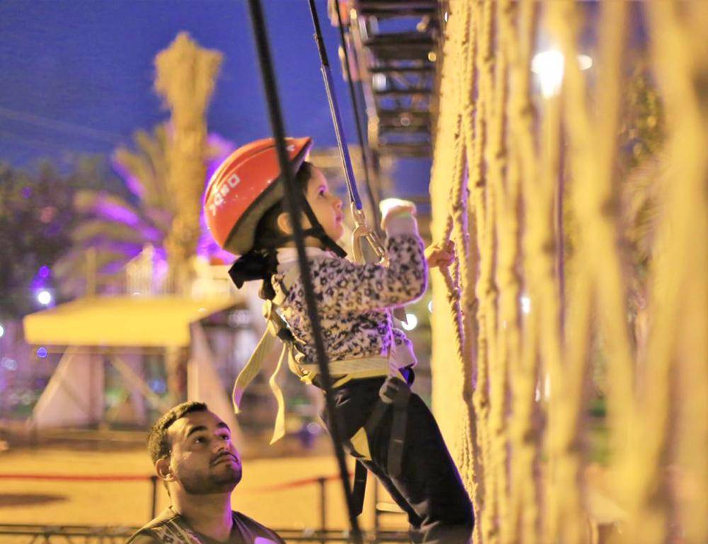 



طفلة تتسلق جدارا ضمن الفعاليات الترفيهية في الفورمولا.