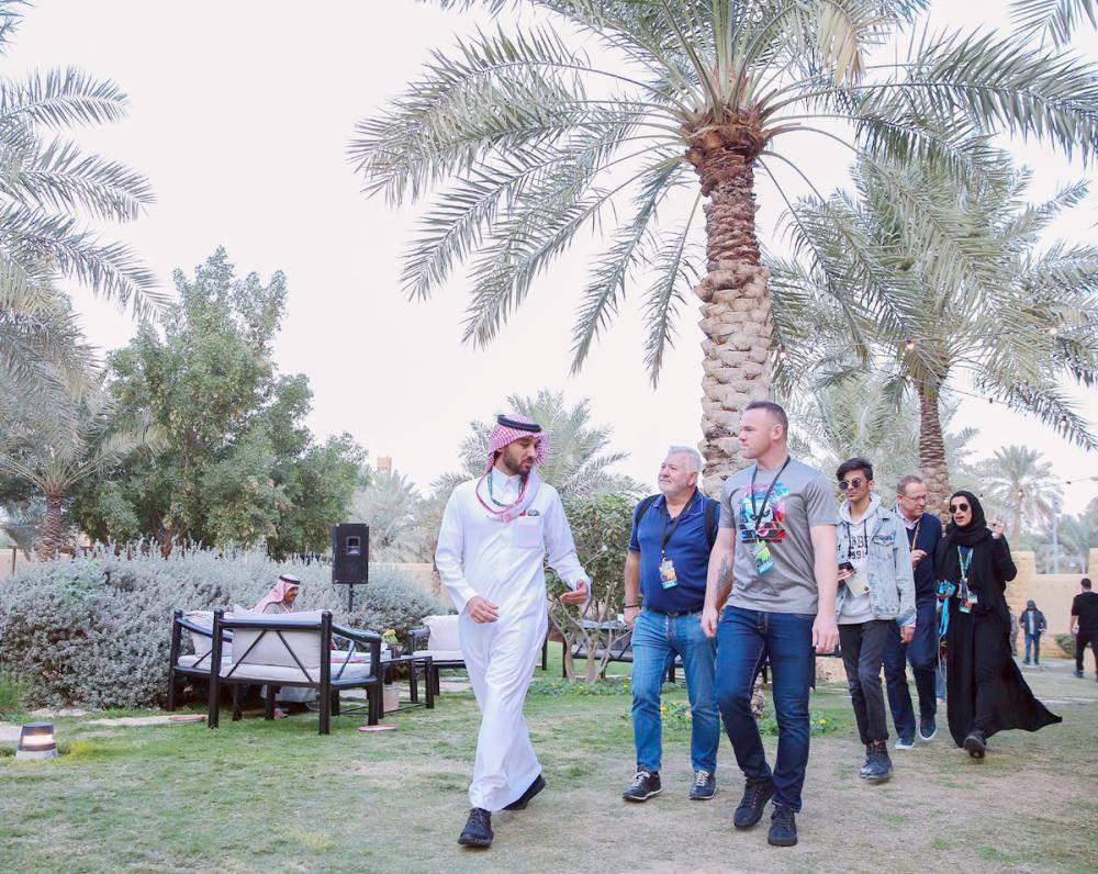 



الأمير عبدالعزيز واللاعب روني خلال الجولة.