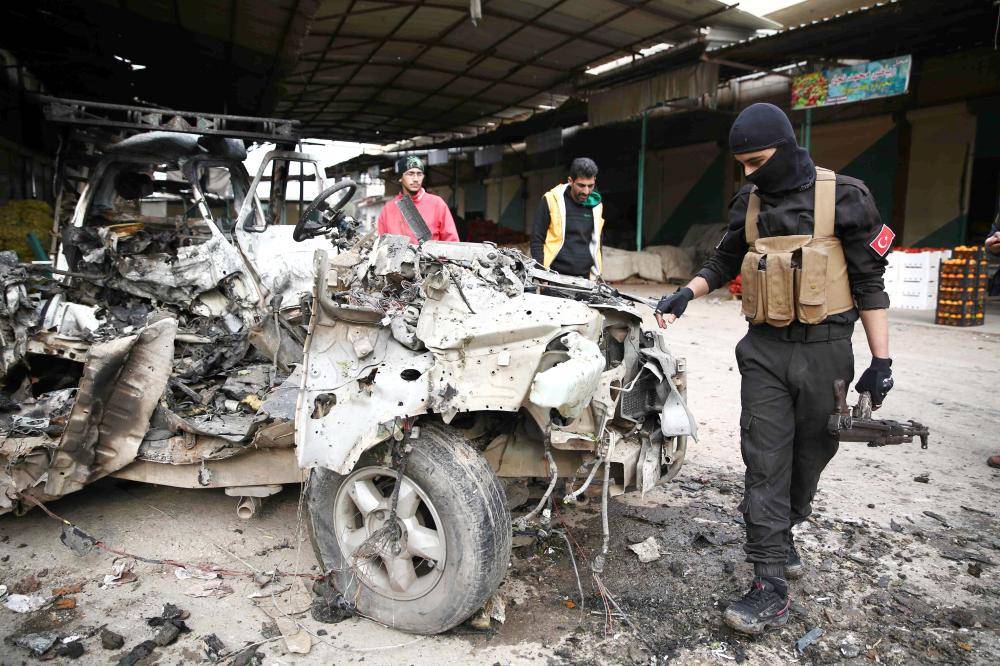 جندي من القوات التركية يتفقد موقع الانفجار بأحد أسواق مدينة عفرين في سورية.  (أ.ف.ب)