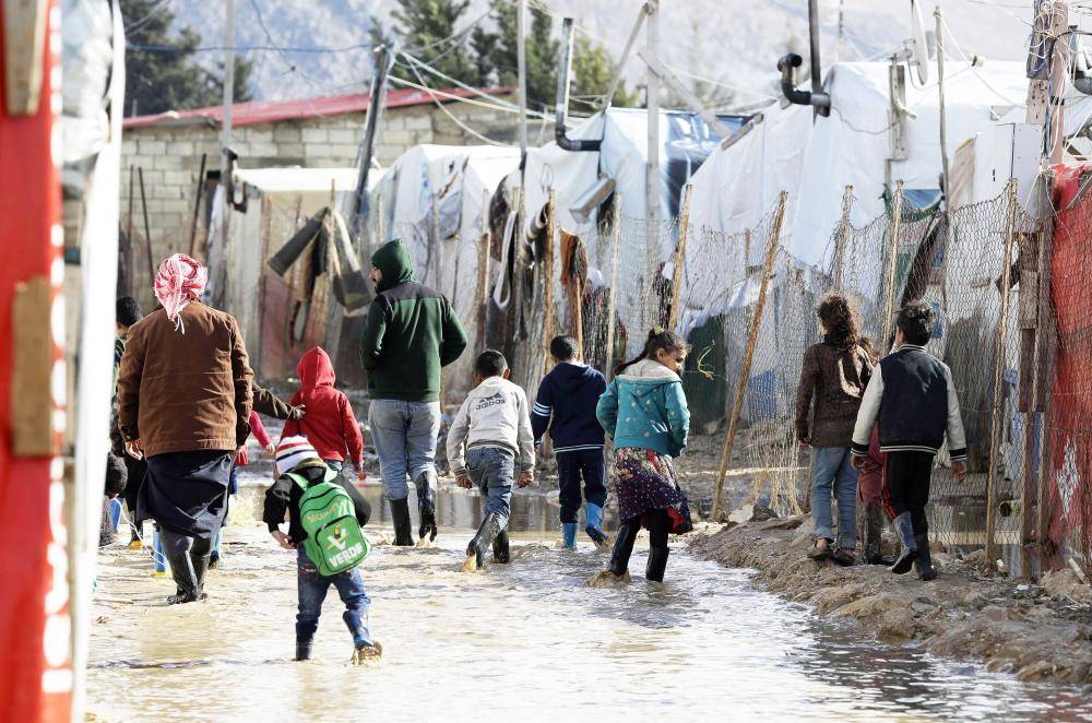 



لاجئون سوريون في مخيمات وادي البقاع في لبنان يعيشون ظروفا مأساوية أمس الأول بسبب العواصف الشتوية. (أ ف ب)