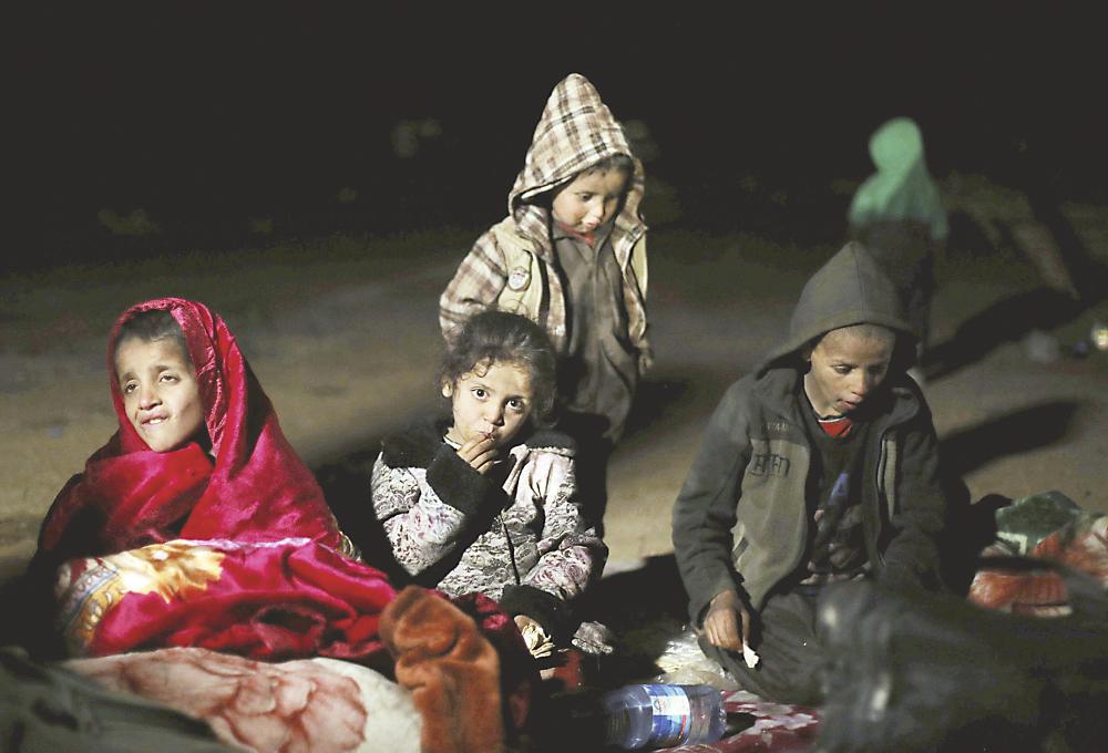 



أطفال سوريون يجلسون بالقرب من قرية الباغوز أمس الأول بانتظار ترحيلهم إلى مخيمات النازحين. (رويترز)
