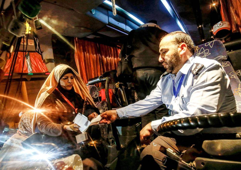 



ضابط من حماس يتفحص وثائق سفر الفلسطينيين المغادرين عند معبر رفح الحدودي بين غزة ومصر أمس. (أ ف ب)