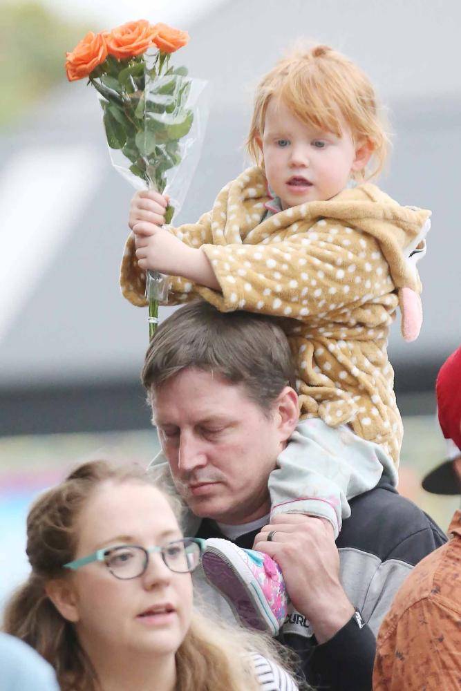 



طفلة نيوزيلندية تحمل زهورا خلال مشاركة عائلتها في تأبين الضحايا. (أ.ف.ب)