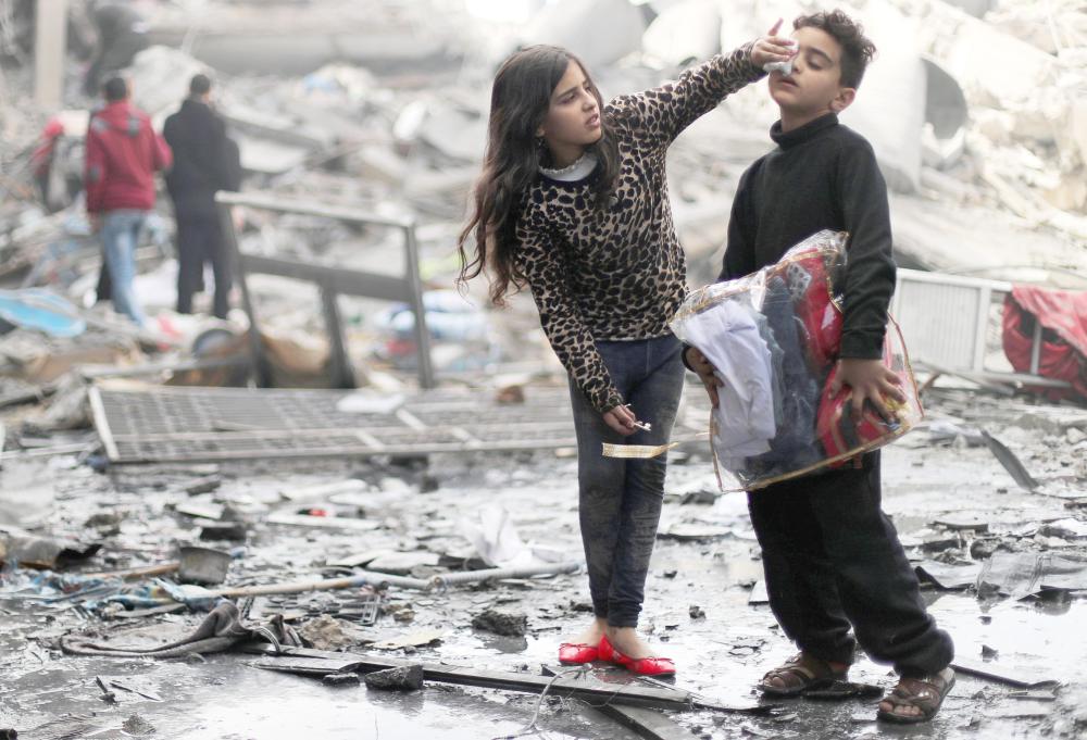 



فتاة فلسطينية تضمد جرحا في وجه شقيقها خارج منزلهما المدمر بعد أن استهدف صاروخ إسرائيلي أمس الأول، موقعا قريبا لحماس في مدينة غزة. (رويترز)