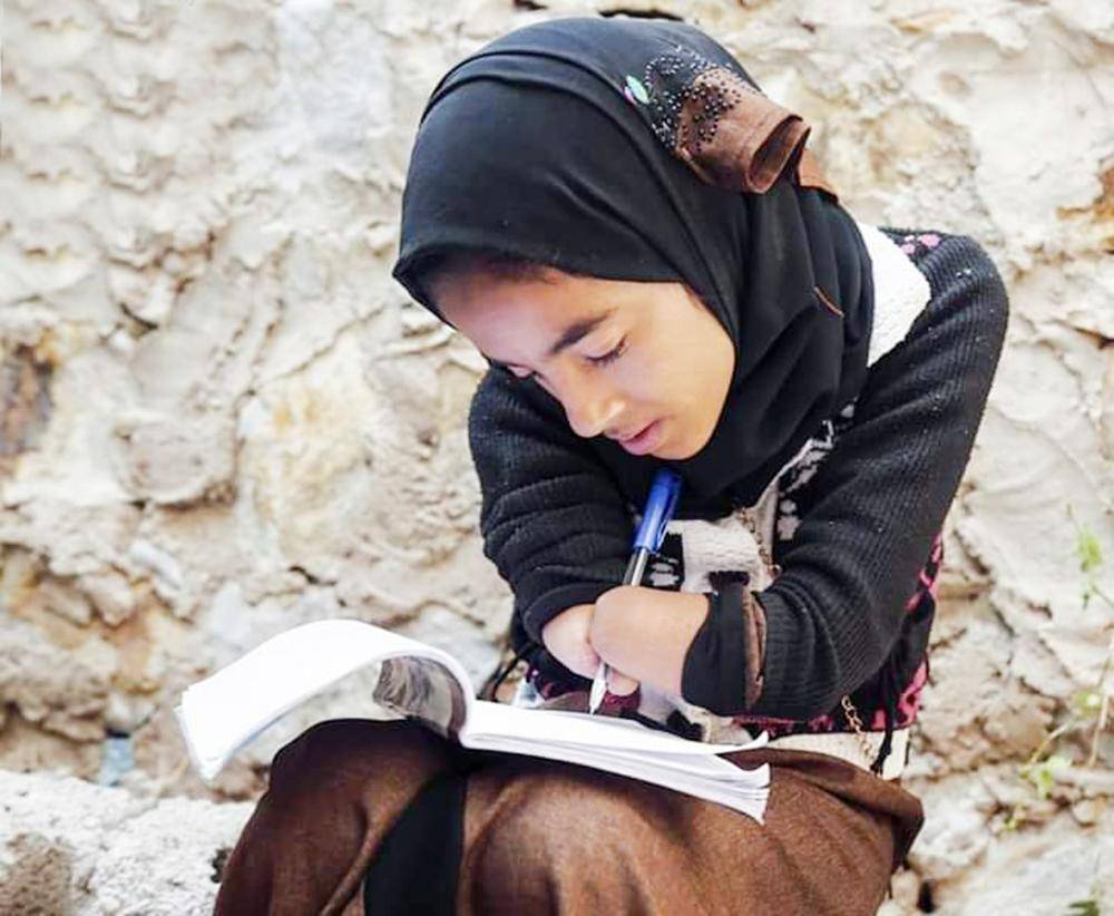 



طالبة يمنية فقدت يديها في انفجار لغم حوثي تراجع دروسها استعدادا للامتحانات في جبل حبشي غرب تعز. (تصوير: أكرم الراسني)