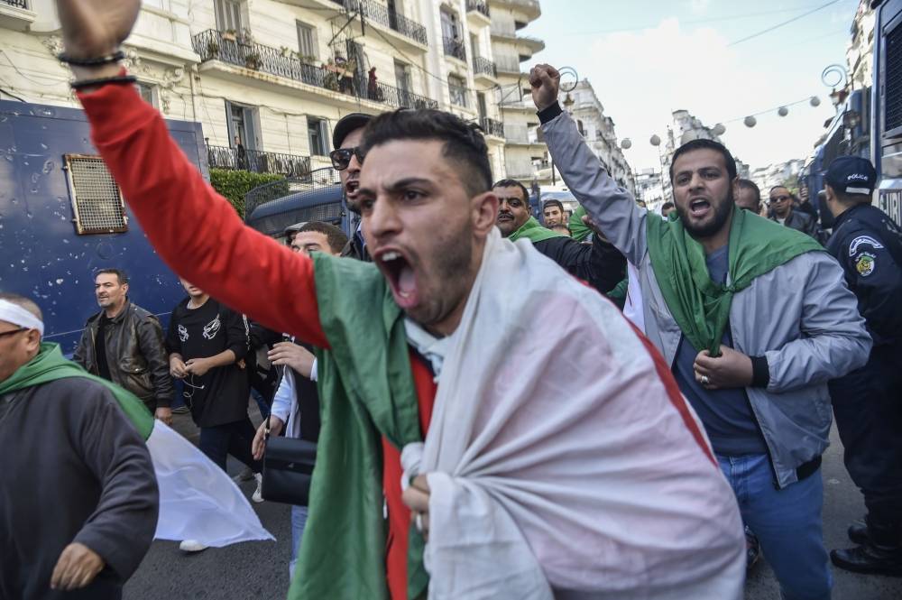 Algerian protesters shout slogans during an anti-system demonstration in the capital Algiers on April 10, 2019, one day after Algerian lawmakers appointed regime stalwart Abdelkader Bensalah as the country's interim president, dismaying protesters seeking sweeping change following the resignation of veteran leader Abdelaziz Bouteflika. Bensalah is a seasoned establishment insider who has a track record of stepping in for his veteran predecessor. / AFP / RYAD KRAMDI 