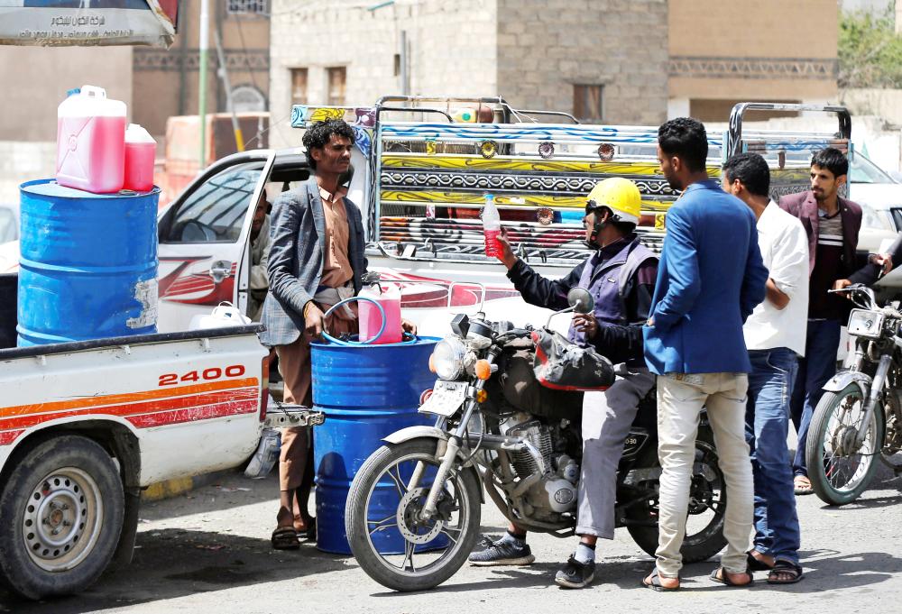 



بائع وقود يبيع البنزين للعملاء في أحد الشوارع وسط نقص في الوقود في صنعاء أمس.  (رويترز) 