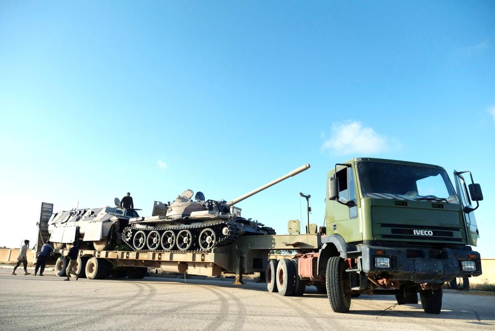 



قوات من الجيش الوطني الليبي يجهزون مركبات عسكرية للخروج من بنغازي إلى طرابلس أمس الأول.  (رويترز)
