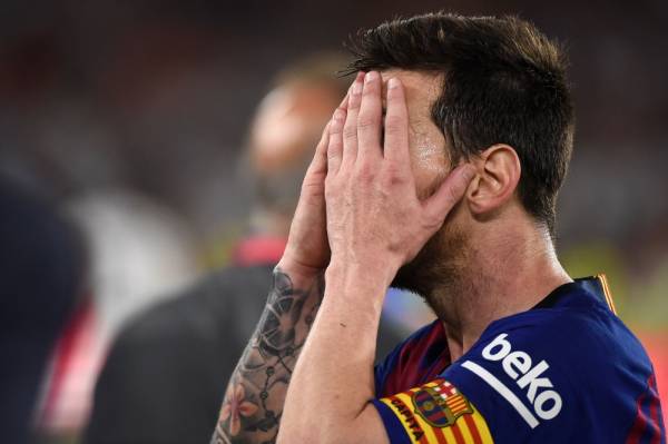 Barcelona's Argentinian forward Lionel Messi covers his face at the end of the 2019 Spanish Copa del Rey (King's Cup) final football match between Barcelona and Valencia on May 25, 2019 at the Benito Villamarin stadium in Sevilla. Barcelona wanted a trophy to ease their Champions League heartache but instead fell to another shock defeat as Valencia pulled off a thrilling 2-1 victory today to win the Copa del Rey. / AFP / JOSE JORDAN 