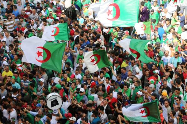 Demonstrators gesture and carry flags during a protest demanding the removal of the ruling elite and prosecution of former officials linked to former President Abdelaziz Bouteflika, in Algiers, Algeria June 14, 2019. REUTERS/Ramzi Boudina