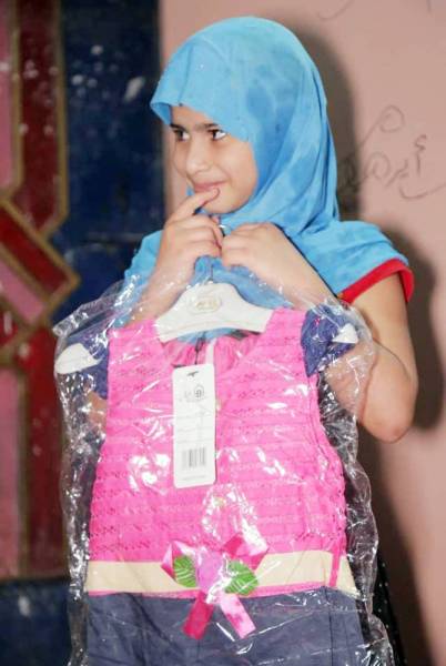 



طفلة تتسلم ملابس جديدة ضمن برامج مركز الملك سلمان للإغاثة. (عكاظ)