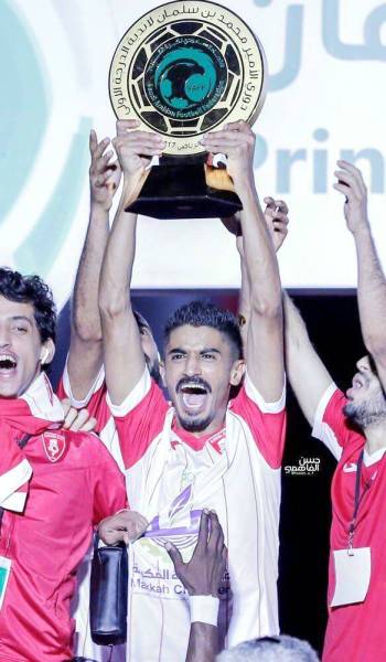 محمد العتيبي يرفع كأس دوري محمد بن سلمان.