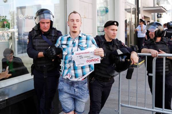 



ضباط الشرطة يعتقلون متظاهرا أثناء تجمع حاشد غير مصرح به في وسط موسكو أمس. (أ.ف.ب)
