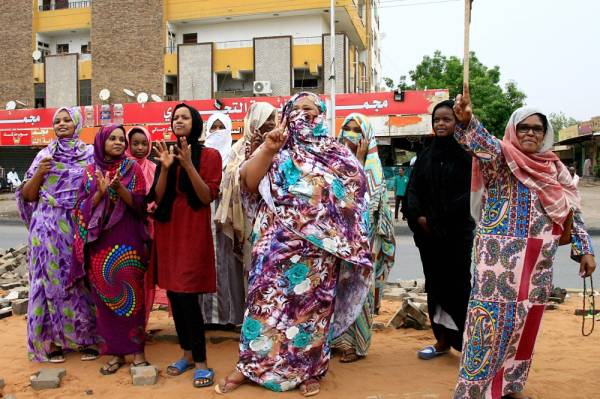 Sudanese demonstraters celebrate in Khartoum early on August 3, 2019, after Sudan's ruling generals and protest leaders reached a «full agreement» on the constitutional declaration. The document is complementary to a power-sharing deal signed on July 17 that aims to form a joint civilian-military ruling body which will oversee the formation of a transitional civilian government and parliament to govern for a three-year transition period. / AFP / Ebrahim HAMID
