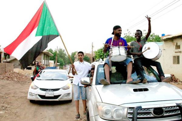 



سودانيون يلوحون بأعلامهم الوطنية أثناء احتفالهم بالخرطوم أمس، بعد أن توصل الجنرالات الحاكمون وقادة الاحتجاج إلى «اتفاق كامل» على الإعلان الدستوري. (أ.ف.ب)