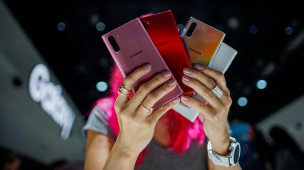 A woman holds different colored models of the Samsung Galaxy Note 10 while people test new devices during the launch event of the Galaxy Note 10 at the Barclays Center in Brooklyn, New York, U.S., August 7, 2019. REUTERS/Eduardo Munoz