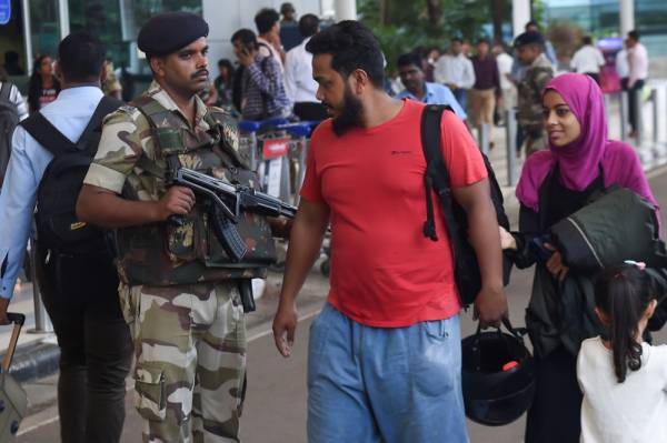 Passengers walk past a Central Industrial Security Force (CISF) soldier standing guard at the domestic airport in Mumbai on August 8, 2019. Indian aviation authorities have asked airports to step up security measures in the days after the government stripped the restive Kashmir of its autonomy, saying «civil aviation has emerged as a soft target for terrorist attacks,» according to the Press Trust of India. / AFP / Indranil MUKHERJEE
