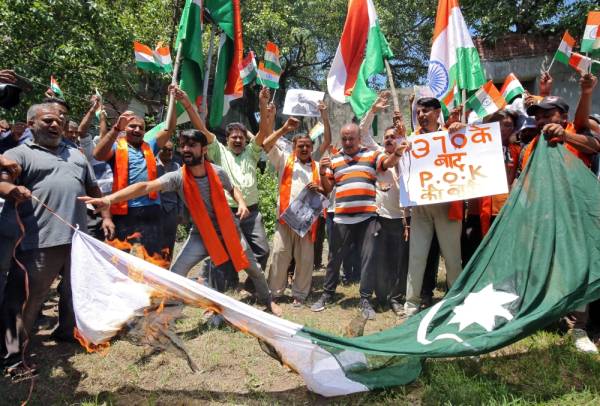 Supporters of Shiv Sena, a Hindu hardline group, burn a flag resembling Pakistan's national flag during a protest, after Pakistan said it would expel India's ambassador and suspend bilateral trade with India, following the scrapping of the special constitutional status for Kashmir by the Indian government, in Jammu August 8, 2019. REUTERS/Mukesh Gupta