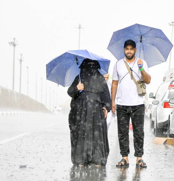 



حاج وحاجة يحتميان من المطر