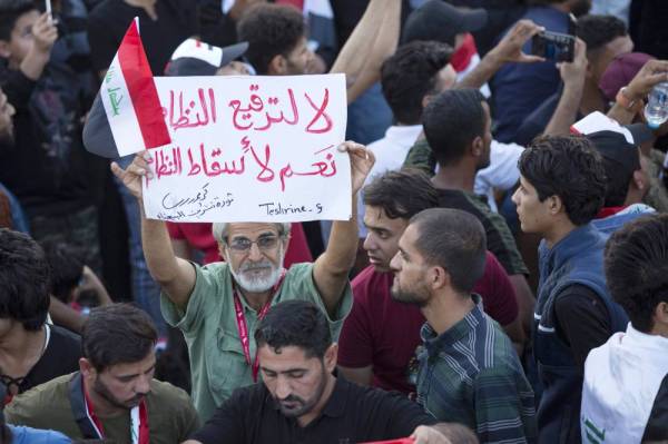 



 عراقي يرفع لافتة تدعو لإسقاط النظام أثناء مشاركته في مظاهرة حاشدة في البصرة أمس الأول. (أ.ف.ب)