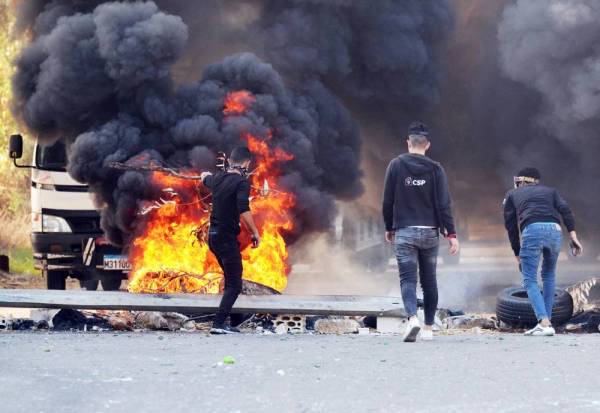 



متظاهرون لبنانيون يحرقون الإطارات لإغلاق الطريق السريع الرئيسي بين طرابلس وبيروت أمس. (أ ف ب)