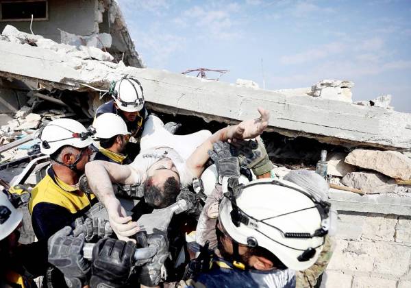 



أفراد الدفاع المدني السوري يحملون مصابا من تحت أنقاض مبنى دمرته غارة لقوات النظام على ريف إدلب أمس. (أ ف ب)