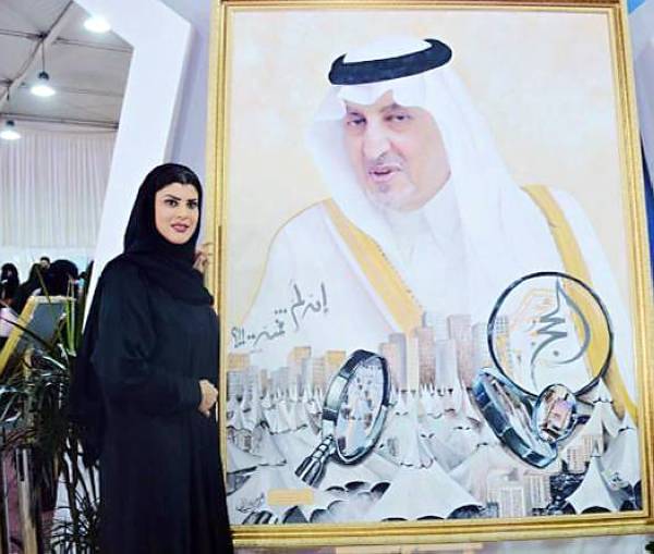 



الأميرة دعاء بنت محمد إلى جانب لوحة للأمير خالد الفيصل.