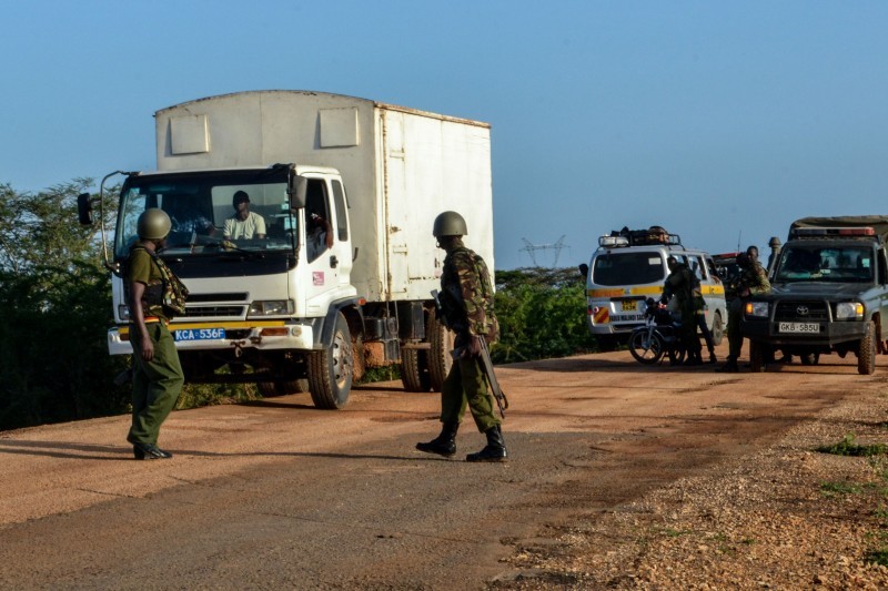 ضباط شرطة في كينيا يفحصون مركبات على طريق بعد كمين لمسلحين استهدفوا حافلة كانت تسير من منطقة لامو إلى مدينة ماليندي. (أ. ف. ب)