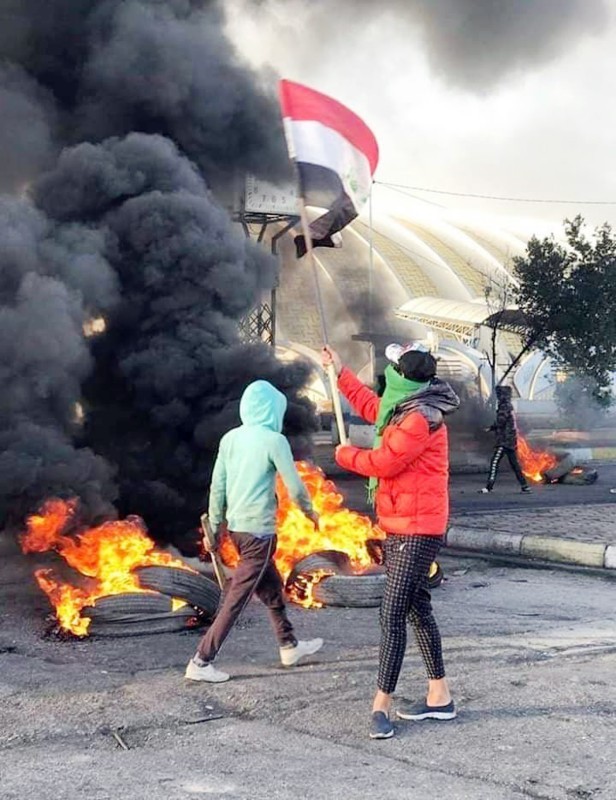 



متظاهر عراقي يشعل النار في إطارات لقطع الطرق في النجف أمس. (وكالات)