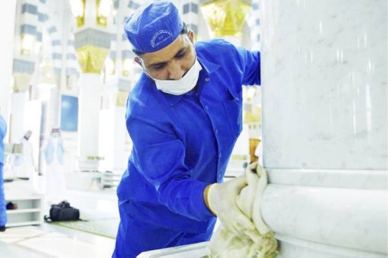 عامل يقوم بتنظيف أحد الأعمدة في المسجد النبوي.