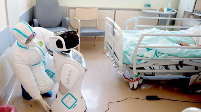 



طبيب في مستشفى إيطالي يجهّز روبوتاً لمساعدته في فحص المرضى. (أ.ب)