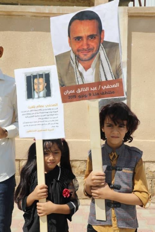 طفلتين تحمل صور والديهما المختطفين في سجون الحوثي في الوقفة الأحتجاجية اليوم (عكاظ)