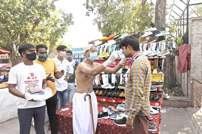 



صبي هندي يرتدي زي المهاتما غاندي يضع قناعاً على وجه بائع متجول في نطاق حملة توعية في نيودلهي.