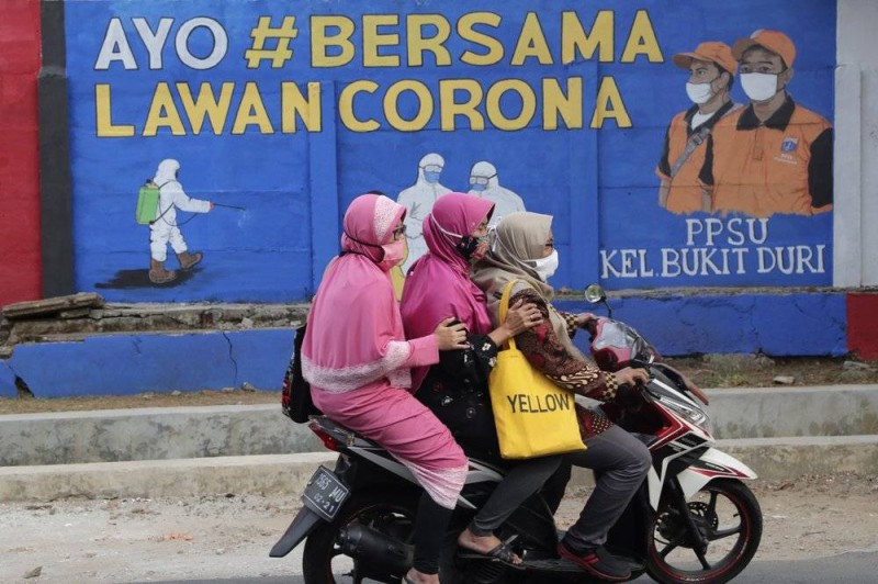 



إندونيسيات على متن دراجة نارية في أحد شوارع جاكرتا.