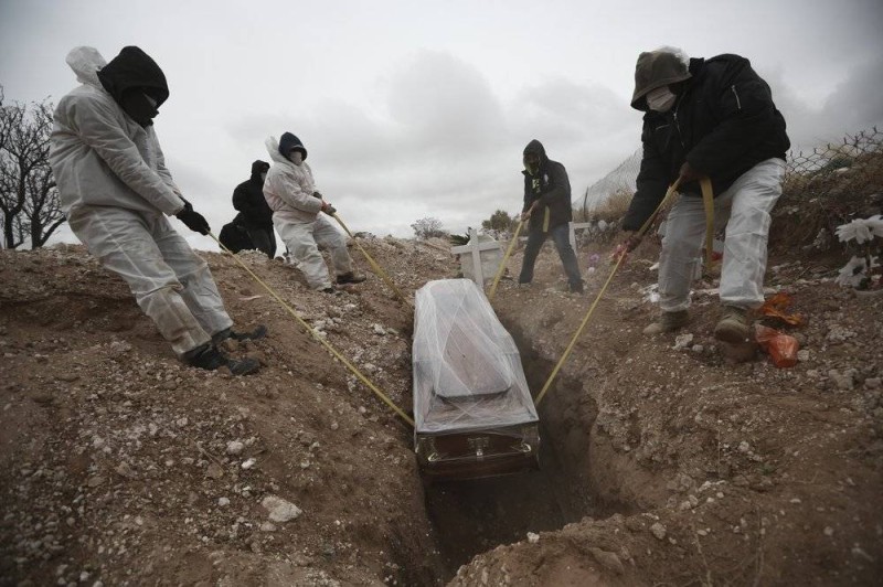 



عمال المقابر المكسيكيون يحاولون إنزال جثمان في القبر.