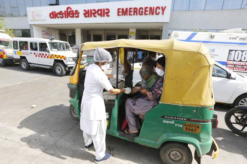 



ممرض في حيدر أباد يكشف على مريضة على متن عربة «ريكشو».
