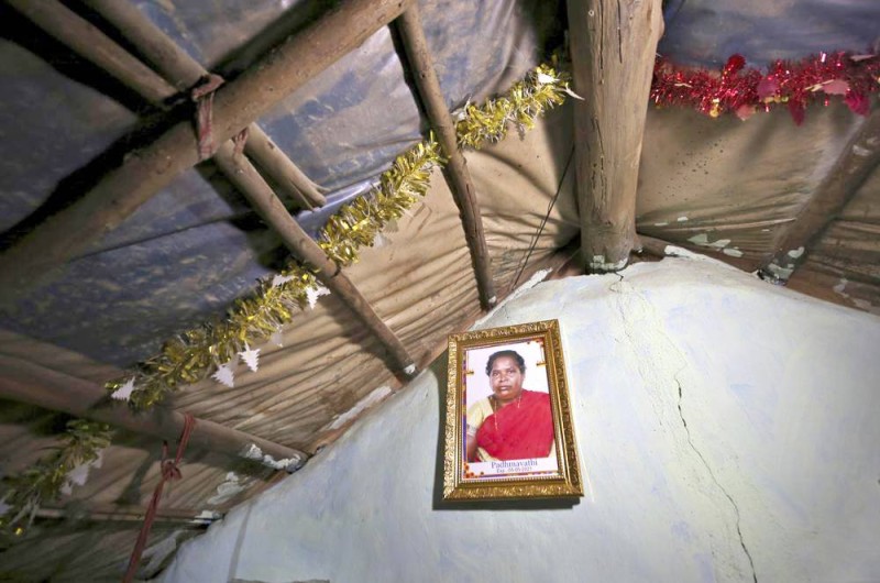 أسرة هندية في بنغالورو علقت صورة والدتهم التي قضت بكوفيد 19 في كوخها.