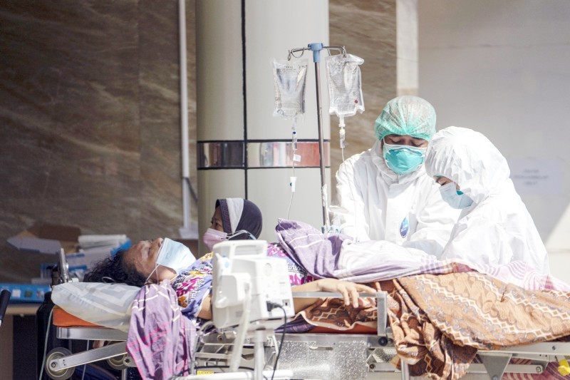 



كادران طبيان يعالجان مصاباً بكوفيد في باكاسي بإندونيسيا.